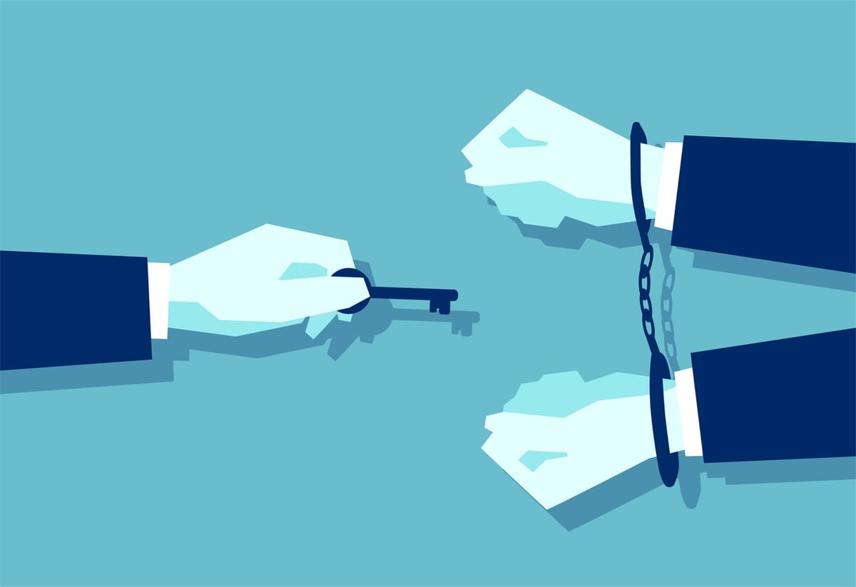 a man with a key reaching out to a man in handcuffs